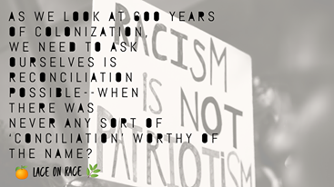 The background shows a hand-painted sign reading "RACISM IS NOT PATRIOTISM" in all caps. Superimposed over that is the text, "As we look at 600 years of colonization, we need to ask ourselves is reconciliation possible--when there was never any sort of ‘conciliation’ worthy of the name?"